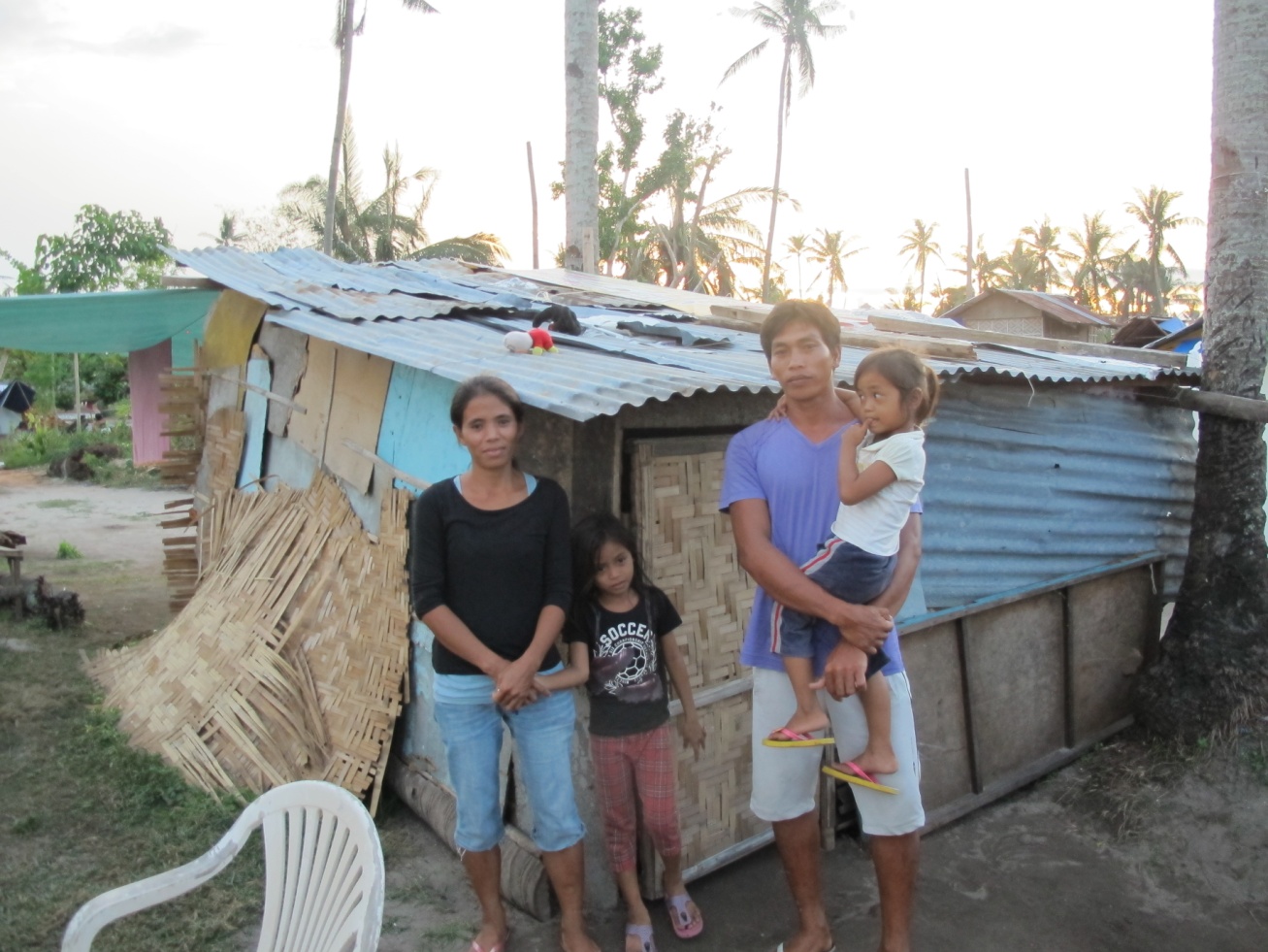 Charis and her family outside their makeshift shelter, in the Philippines