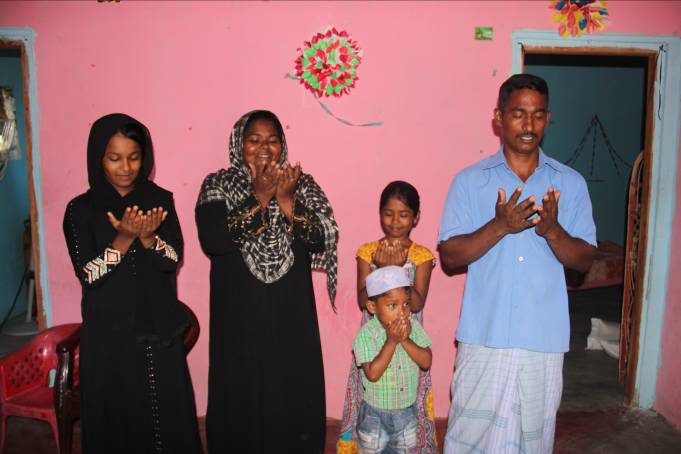 Basheer and his family give thanks to God for their food parcel.