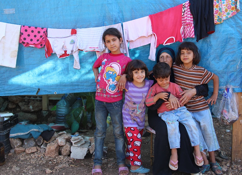 Um Mohamed with her grandchildren outside their tent.
