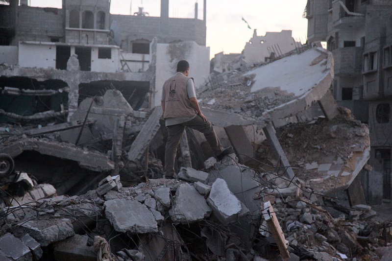 An Islamic Relief aid worker surveys the ruins of a home in Gaza.