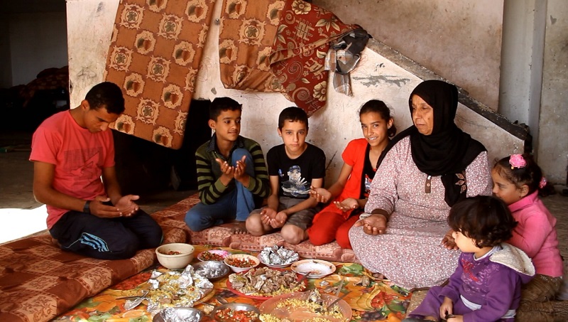 Hanan and her children give thanks to God for their meal, made with Qurbani meat.