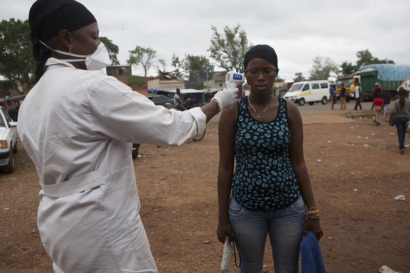 A health worker checks the temperature of a woman entering Mali from Guinea at the border in Kouremale, October 2, 2014. REUTERS/Joe Penney