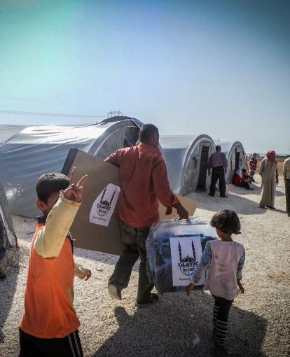 A refugee family with their aid items, in a camp in Turkey. 