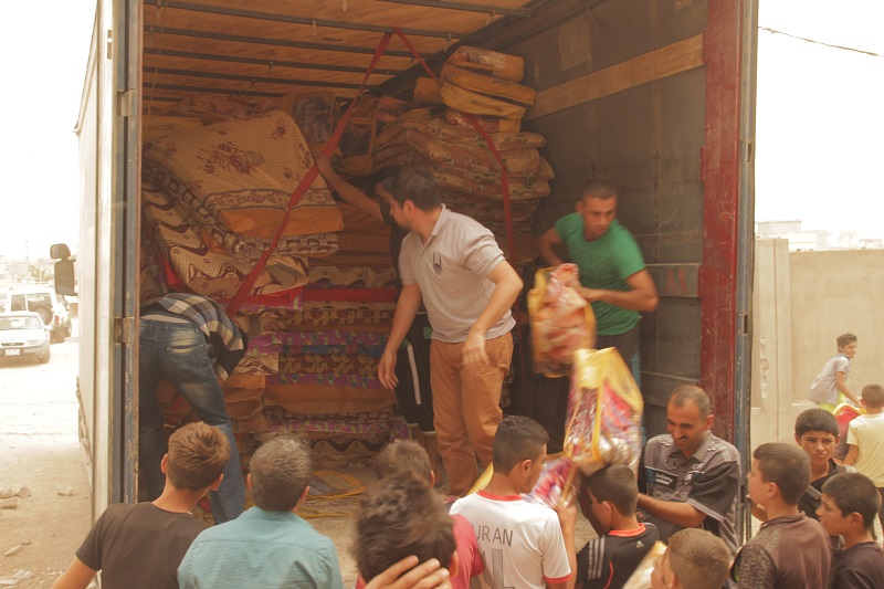 Displaced people help unload the Islamic Relief aid items in Sinjar.