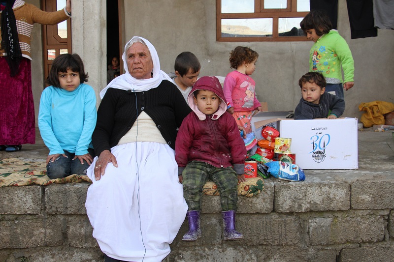 A family in Duhok with their Islamic Relief aid items.