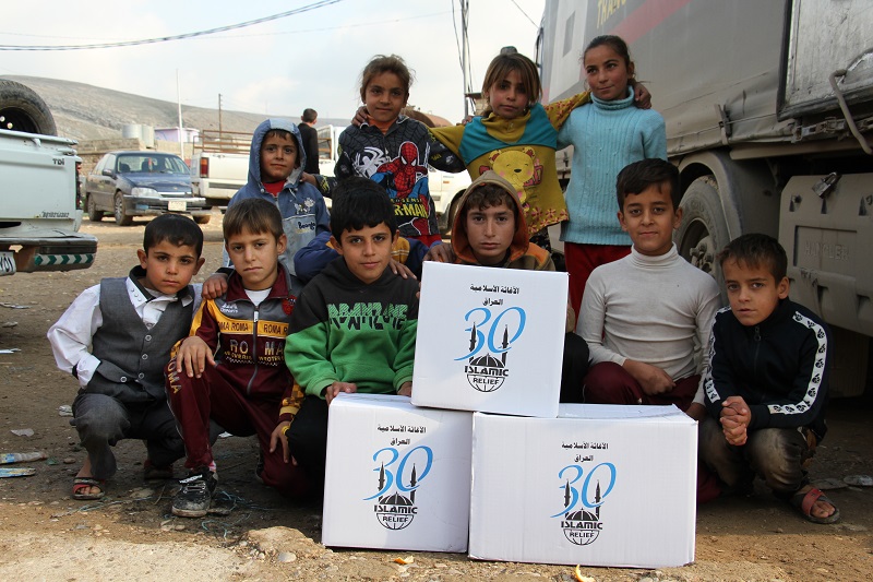 Displaced children in Duhok with Islamic Relief aid items.
