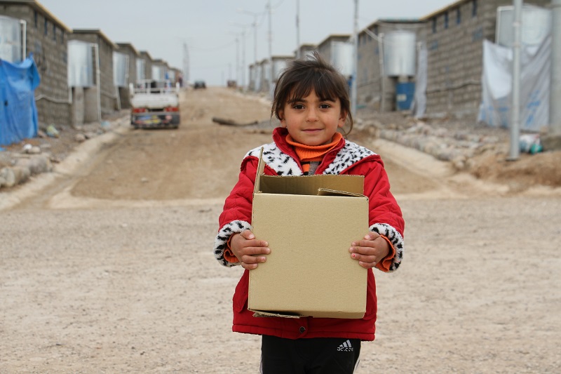 A Syrian girl receives an Islamic Relief aid pack in a refugee camp in Iraqi-Kurdistan.