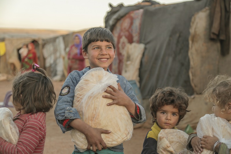 Um Khaled's grandchildren with bread provided by Islamic Relief.