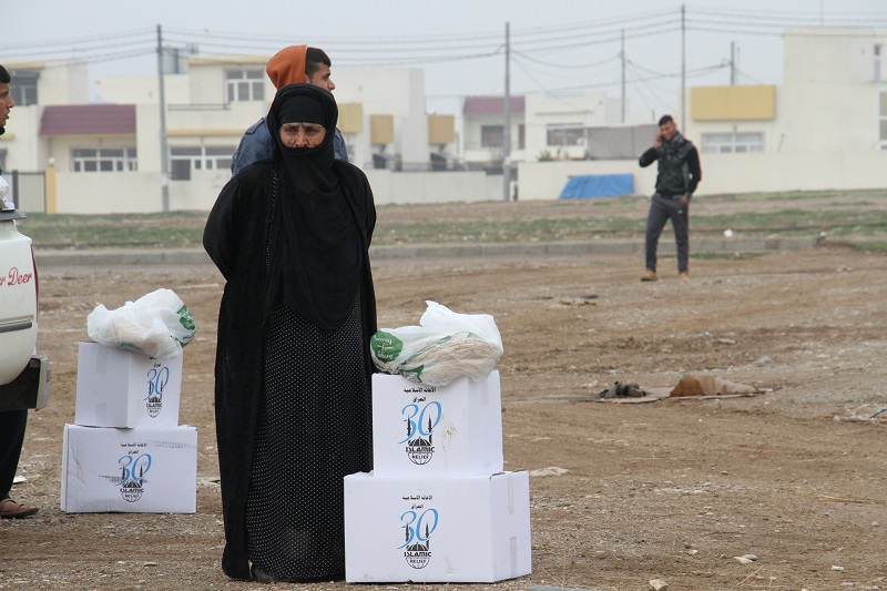 A displaced woman in Erbil receives food and hygiene items.