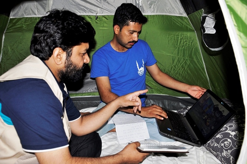 Umair Hassan and Haseeb Khalid, from Islamic Relief, discussing from their tent.