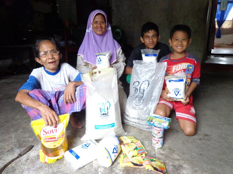 Zainuddin and his brother, Hamandi, 16, unpack the food parcel with their mother and grandmother.
