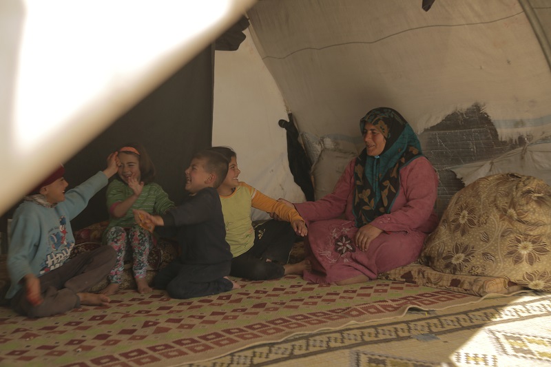Um Mohammed with her grandchildren, inside their tent.