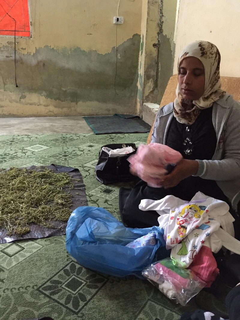 Kawthar, who has been drying camomile to help with the birth of her baby girl, with the items she has bought for the baby.