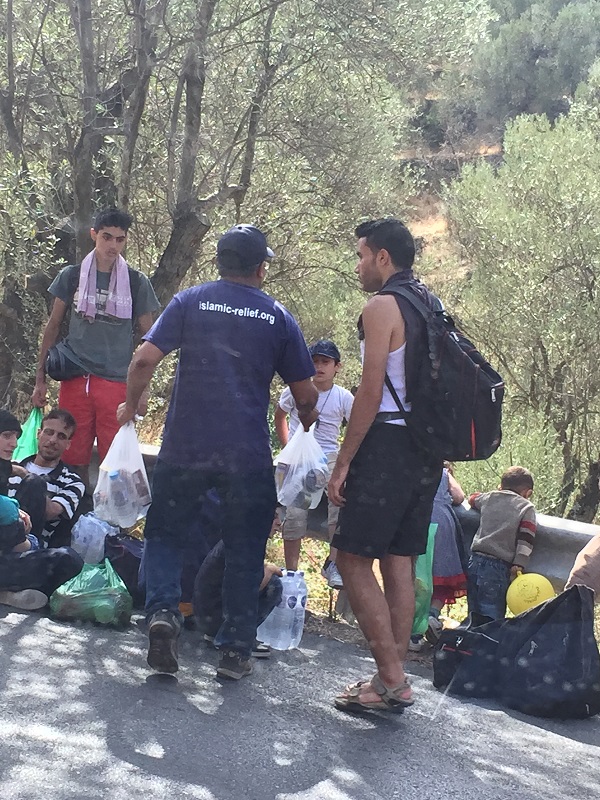 Islamic Relief staff provide food and water to refugees undertaking a gruelling trek to Kara Tepe camp.