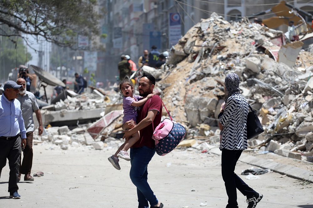 A family amid the rubble on Al Wahda street, Gaza.