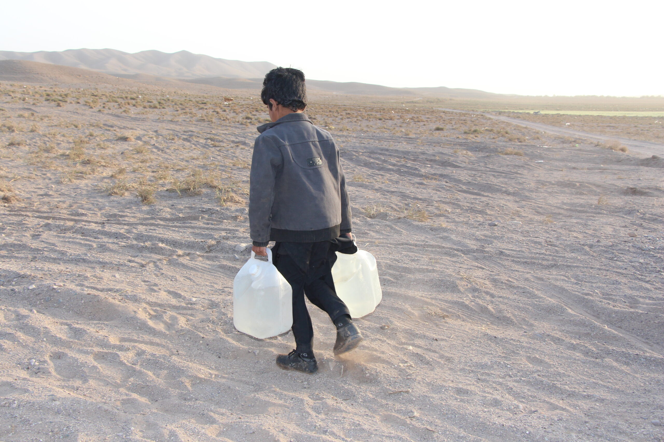 طفل يحمل مياه نظيفة سلمتها الإغاثة الإسلامية في زنداجان