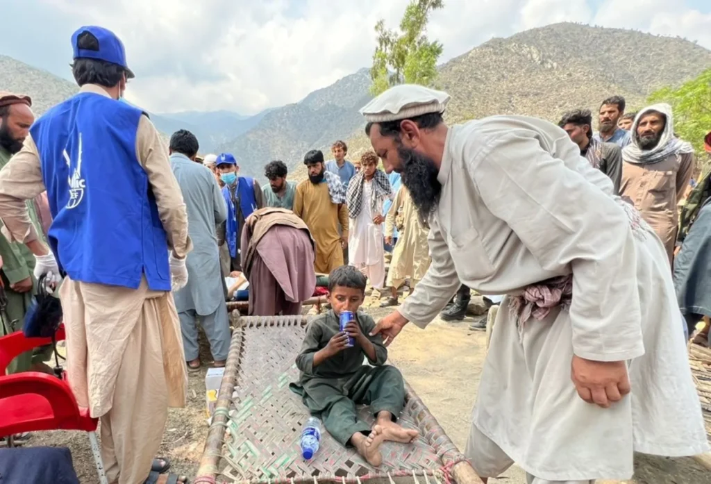 Islamic Relief supports victims of the earthquake in Afghanistan. A little boy sitting drinking water